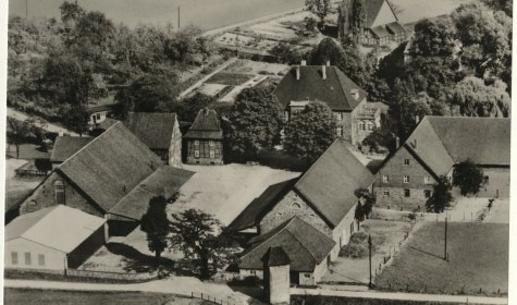 Ein Luftbild des Hofs Nacke mit mehreren Gebäuden in Ehrsen ist zu sehen, die Aufnahme ist schwarzweiss und um 1955 datiert