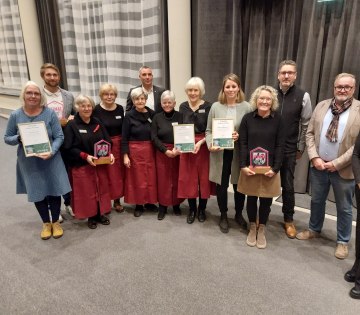 Große Freude bei der Verleihung des Heimat-Preises 2024: Die drei Erstplatzierten – die Realschule Aspe, das
„Café am Kirchplatz“ in Schötmar und der „Kulturring Wüsten e.V“ – erhielten die Awards und Urkunden von Bürgermeister Dirk Tolkemitt (hintere Reihe, 2.v.l.) und Franziska Hildebrand (rechts, Stab Ehrenamt & Sport Stadt Bad Salzuflen)., © Stadt Bad Salzuflen