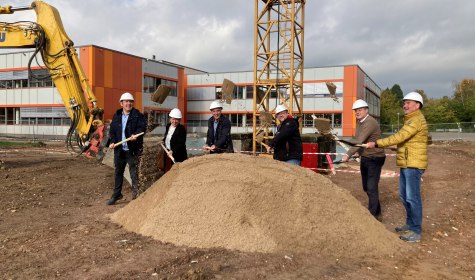 Mehrere Personen mit Bauhelm und Spaten stehen auf einer Baustelle und vollziehen einen symbolischen ersten Spatenstich, es handelt sich um Mitglieder von Stadtverwaltung, Politik und Fachfirmen, © Stadt Bad Salzuflen