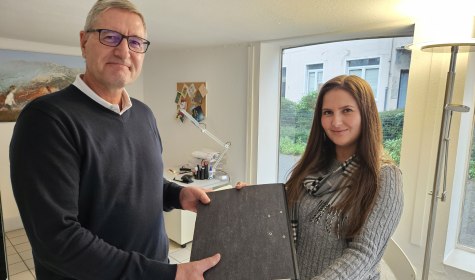 Die scheidende Quartiersmanagerin Melissa Parlapanos übergibt einen Aktenordner an den neuen Quartiersmanager Knut Hallmann, © Quartiersmanagement Schötmar