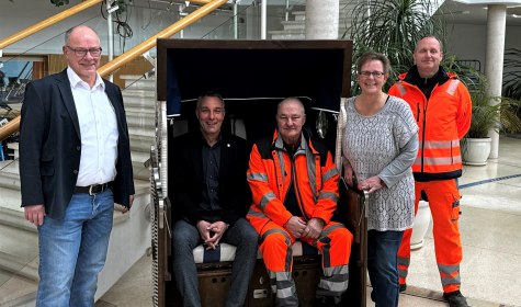 Jubilar Heinz-Dieter Kist (sitzend rechts, Abteilung Baubetriebshof) wurde im Rahmen einer Feierstunde von Bürgermeister Dirk Tolkemitt (sitzend links) geehrt. Zu den Gratulanten gehörten auch Personalratsvorsitzender Dirk Strehle (stehend links), Ariane Schlüter (stehend 2.v.r., Erste stellv. Personalratsvorsitzende) und Baubetriebshof-Mitarbeiter Markus Albert. , © Stadt Bad Salzuflen